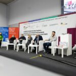 учасники презентації сидять на стільчиках на фоні банера про Альбом